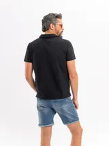 Remera tipo polo de manga corta con textura cloqué en color gris, de corte clásico y cuello camisero con abertura frontal.