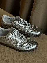 Championes de estilo urbano en color plateado metalizado con acabado texturizado. Presentan cordones blancos, suela de goma oscura y un detalle lateral en forma de estrella. Diseñados con doble plantilla acolchada para mayor comodidad.