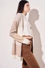 Cárdigan largo de punto con diseño color block en tonos beige, marrón y blanco. Tiene bolsillos delanteros y corte holgado.