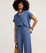 Pantalón celeste de corte recto, confeccionado en tejido orly con elástico y lazo en la cintura.