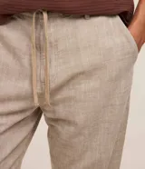Pantalón masculino relaxed fit confeccionado en oxford de algodón, color beige, con trabillas en la cintura y cordón ajustable con lazo. Cuenta con bolsillos delanteros y traseros.