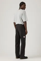 Pantalón tipo carpenter de corte holgado y recto, con diseño de cinco bolsillos y costuras reforzadas características del estilo utilitario.