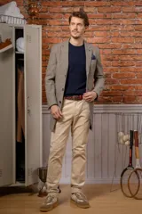 Chaquetón de corte slim fit confeccionado en una mezcla de seda y lana, color gris con textura jaspeada. Presenta solapas clásicas, cierre frontal de botones y bolsillo en el pecho con pañuelo decorativo.