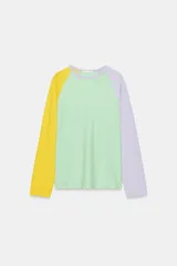 Camiseta de manga larga con diseño tricolor y patrón de rayas diagonales. Presenta cuerpo con rayas en verde y blanco, manga izquierda amarilla y manga derecha lila, con cuello redondo.