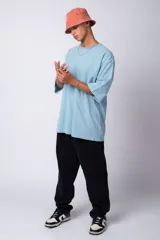 Remera de corte oversize, color blanco, con cuello redondo y mangas cortas amplias.