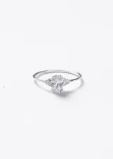 Anillo de plata 925 con diseño minimalista, presenta una zirconia central de corte ovalado flanqueada por pequeñas piedras brillantes en ambos lados.
