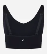 Top deportivo negro, confeccionado en tejido seamless de poliamida y elastano, con escote en U y breteles ajustables. Presenta una banda inferior texturizada y copas removibles.