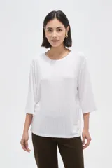 Remera de viscosa en color verde oliva, con cuello redondo y mangas 3/4. Presenta un diseño de tejido acanalado y corte holgado.