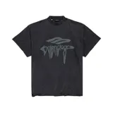 Camiseta de algodón color negro con efecto desgastado y roturas sutiles. Presenta un estampado frontal con el logo de la marca en estilo líquido y un emblema superior en tono gris oscuro. Posee cuello redondo y corte oversize.