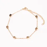 Pulsera dorada de cadena fina con eslabones pequeños y dijes de cubos espaciados. Cierre con mosquetón y cadena de alargue.