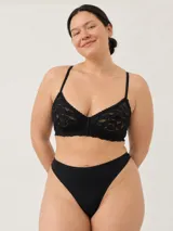 Soutien negro confeccionado en encaje con diseño floral, tirantes finos regulables y cierre posterior.