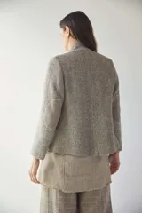 Chaqueta corta color marrón con cuello solapa y diseño con patchwork de telas. Manga larga con detalle de coderas aplicadas. Cierre frontal mediante botones y bolsillos ojal. Con forro.