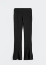 Pantalón negro acampanado de lana, con dos bolsillos de ribete en la parte delantera.
