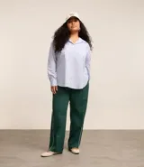 Pantalón recto verde oscuro con cintura elástica y vivos laterales blancos.