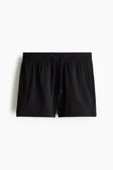 Short de baño negro de sirsaca con cintura elástica y cordón de ajuste. Cuenta con bolsillos laterales y pantaloncillo interior de malla.
