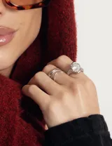 Anillo de acero quirúrgico con diseño de banda irregular y piedra central engastada.