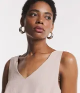 Mono largo negro de poliéster con escote en V, sin mangas, corte midi y elástico en la cintura. Presenta bolsillos laterales y corte holgado.