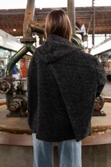 Campera tipo overshirt de paño jaspeado en color negro, con calce oversize, capucha y cordones trenzados. Presenta un diseño versátil con interior suave y abrigado.