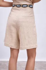 Short color beige con cintura elastizada y aplique bordado en la cintura.