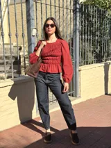 Blusa bordó con diseño fruncido mediante elásticos en el cuerpo y mangas largas abullonadas con puños elásticos.