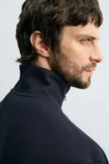 Sudadera roja de corte regular, con cuello alto y cierre frontal de cremallera. Manga larga y terminaciones en rib.