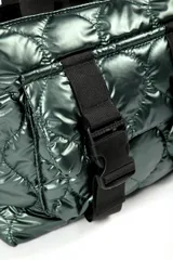 Cartera tipo tote bag color verde oscuro brillante, con diseño acolchado y correas negras. Presenta dos correas frontales con hebillas de plástico negras y un bolsillo frontal.