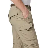 Pantalón convertible de trekking color beige, con diseño desmontable que permite transformarlo en short. Cuenta con múltiples bolsillos, incluyendo bolsillos laterales con cierre, y cintura con cinturón integrado.