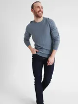 Sweater de lana merino 100% de corte regular, color azul grisáceo, con cuello redondo y puños y dobladillo de punto acanalado. Presenta un logotipo de monograma tonal de Calvin Klein en el pecho.