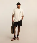 Bermuda masculina de poliéster, color negro, con lazo en la cintura, bolsillos y detalle de etiqueta gomosa.