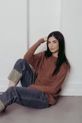 Sweater de punto con textura de ochos verticales, cuello redondo, mangas largas con puños acanalados y silueta relajada.