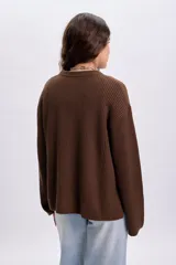 Buzo de punto color marrón con cuello redondo, mangas largas y diseño holgado.