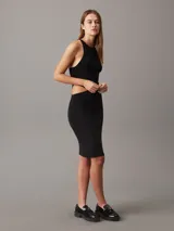 Vestido midi negro de punto de rayón suave, corte slim, cuello redondo, espalda cruzada y detalle recortado en la cintura.