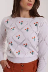 Sweater blanco de tejido de punto calado con diseño de rombos y flores bordadas en color naranja y verde.