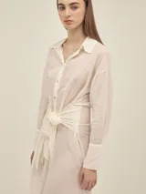 Vestido camisero largo negro con botones nacarados, lazo en la cintura y detalle de Polonio en cobre.