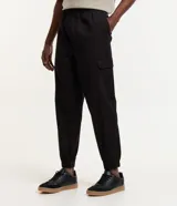 Pantalón jogger negro de sarga de algodón y elastano, con bolsillos cargo laterales y tobillos ajustados.