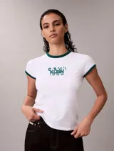 Remera Calvin Klein ajustada de color blanco, con cuello redondo y ribetes en las mangas de color verde oscuro. Presenta un estampado gráfico frontal con el texto "Calvin Klein 1968" en tono verde.