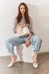 Mocasines de cuero color dorado con acabado texturizado, diseño clásico de punta redondeada y costuras visibles en el empeine. Cuentan con suela plana y flexible.