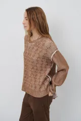 Buzo reversible de tejido de punto con diseño de trenzas, cuello redondo y mangas largas. Presenta una combinación de colores en contraste, con un lado en violeta y el otro en marrón oscuro.