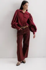 Pantalón de jean color bordó, corte baggy, tiro medio, con cuatro bolsillos y pinzas en las rodillas.