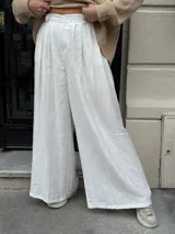 Pantalón sastrero marrón de corte palazzo, con botón, pasacinto y pretina trasera con elástico.