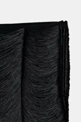 Falda mini de tiro medio color negro, confeccionada con capas de flecos a tono que crean un efecto de movimiento. Cuenta con forro interior y cierre lateral con cremallera.