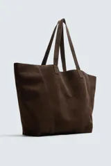 Bolso tipo shopper de piel con acabado serraje color camel, con dos asas de mano y bolsillo interior con cierre de cremallera.