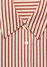 Camisa de corte recto y diseño a rayas verticales en tonos terracota y blanco, con cuello camisero, cierre frontal de botones y mangas largas con puños abotonados.