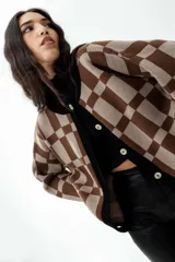 Cárdigan marrón con diseño a cuadros beige, con cuello, puños y borde inferior negros.