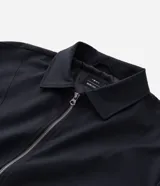 Campera boxy de poliéster color beige, con cuello inglés, cierre frontal de cremallera, mangas largas con elástico en los puños, bolsillos laterales y detalles de recortes.