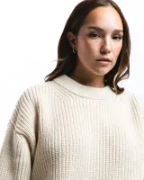 Sweater unisex color crema de lana merino, con cuello redondo y corte holgado.