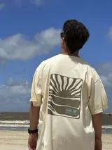Remera color crema de algodón con estampa en la espalda de un paisaje playero con el texto "Chema Sure Chate et la mer".