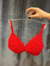 Bralette de encaje rojo con escote en V y bordes festoneados. Presenta tirantes finos ajustables.
