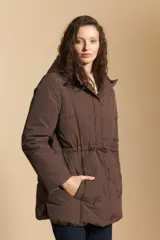 Campera acolchada de nylon en color crema, con capucha ajustable, cierre frontal con botones y cordón de ajuste en la cintura.