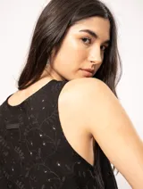 Top de lino color crema, sin mangas, con escote redondo y bordados florales.